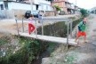 Crianças em pinguela sobre o córrego Monte Alegre e aspecto do bairro de mesmo nome, com problemas ambientais entre outros<br />Foto Fábio Lima 