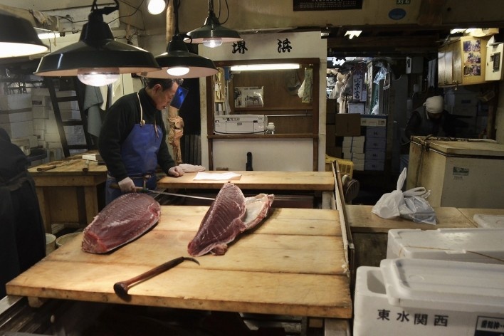 Mercado de peixe Tsukiji, peixeiro com espada estudando o pedido, Tóquio<br />Foto Roberto Abramovich 