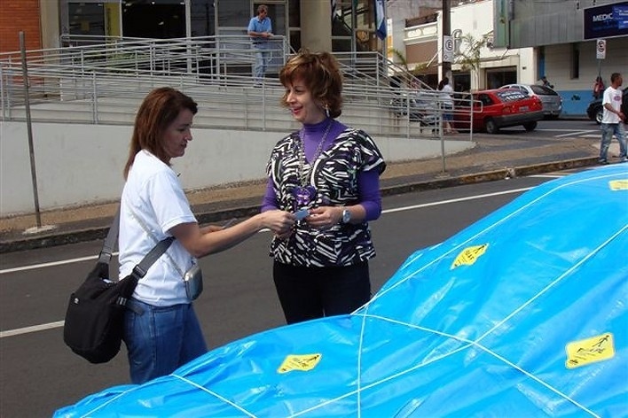 Artista entrega adesivo do projeto Fui a Pé a motorista no centro de Limeira<br />Foto divulgação 