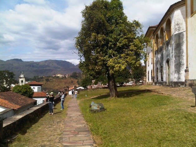 Canaleta e caminho de pedra, gramado e árvore ao lado da igreja São Francisco de Assis<br />Foto Abilio Guerra 