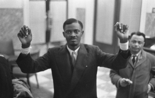 O líder congolês Patrice Lumumba durante mesa redonda em conferência, Bruxelas, janeiro de 1960<br />Foto Anefo 910-9738 De Congolese / Nationaal Archief, Den Haag, Rijksfotoarchief  [Fotocollectie Algemeen Nederlands Fotopersbureau (ANEFO), 1945-1989 / Wikimedia Commons]