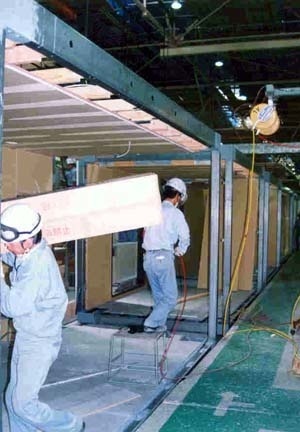 Operários trabalhando na linha de montagem em uma indústria de sistema industrializados de construção no Japão