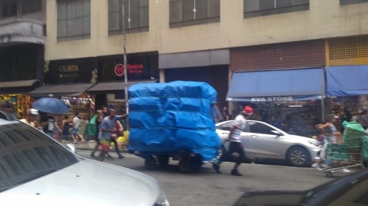 Rua 25 de Março, ambulante do tipo móvel carregando carrinho no final do expediente, São Paulo SP<br />Foto Mariana Taguti, 2019 